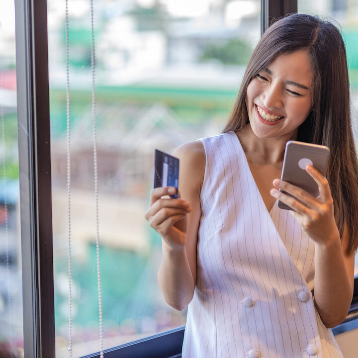 Asian businesswoman in casual suit doing online shopping by using credit card