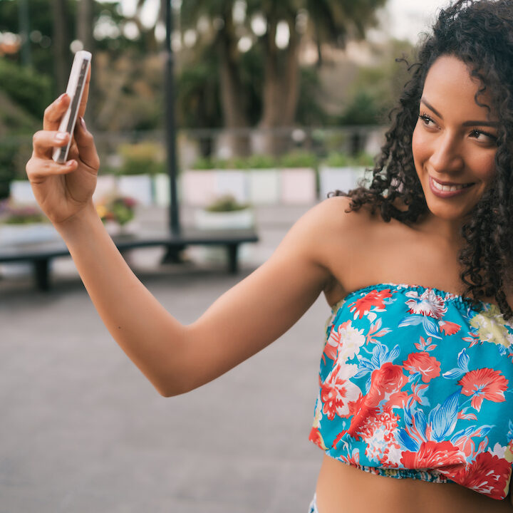 Afro American latin woman taking a selfie with phone.