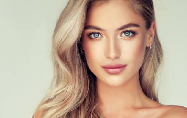 Confident brunette woman with clear, radiant skin after personalized facial aesthetic treatments in Columbus.