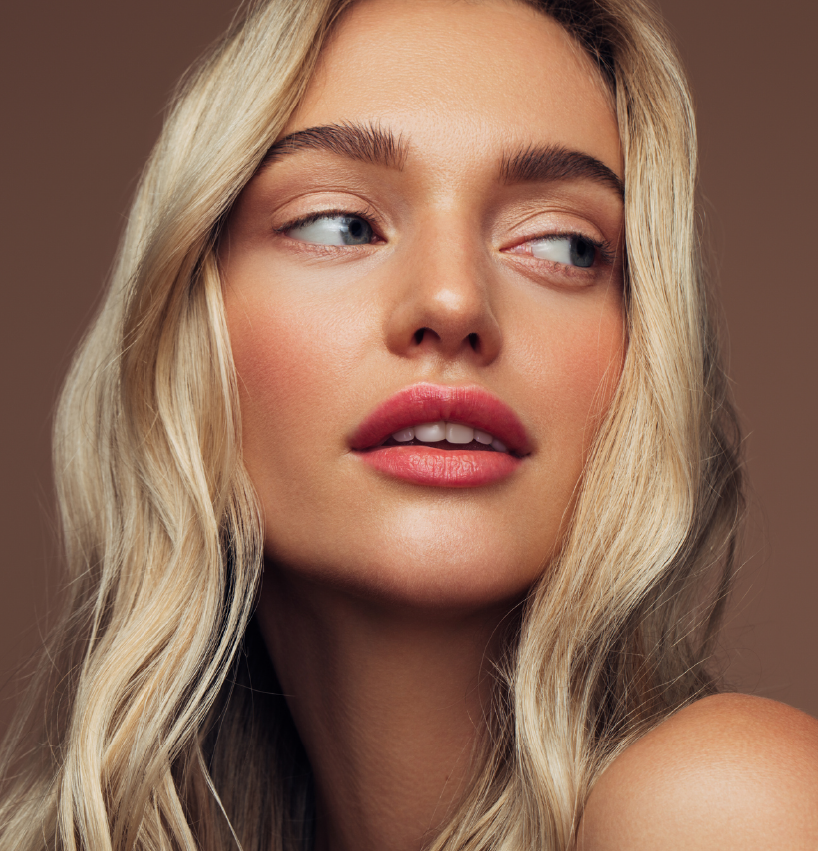 Close-up of a woman with radiant skin and soft makeup, highlighting facial rejuvenation results